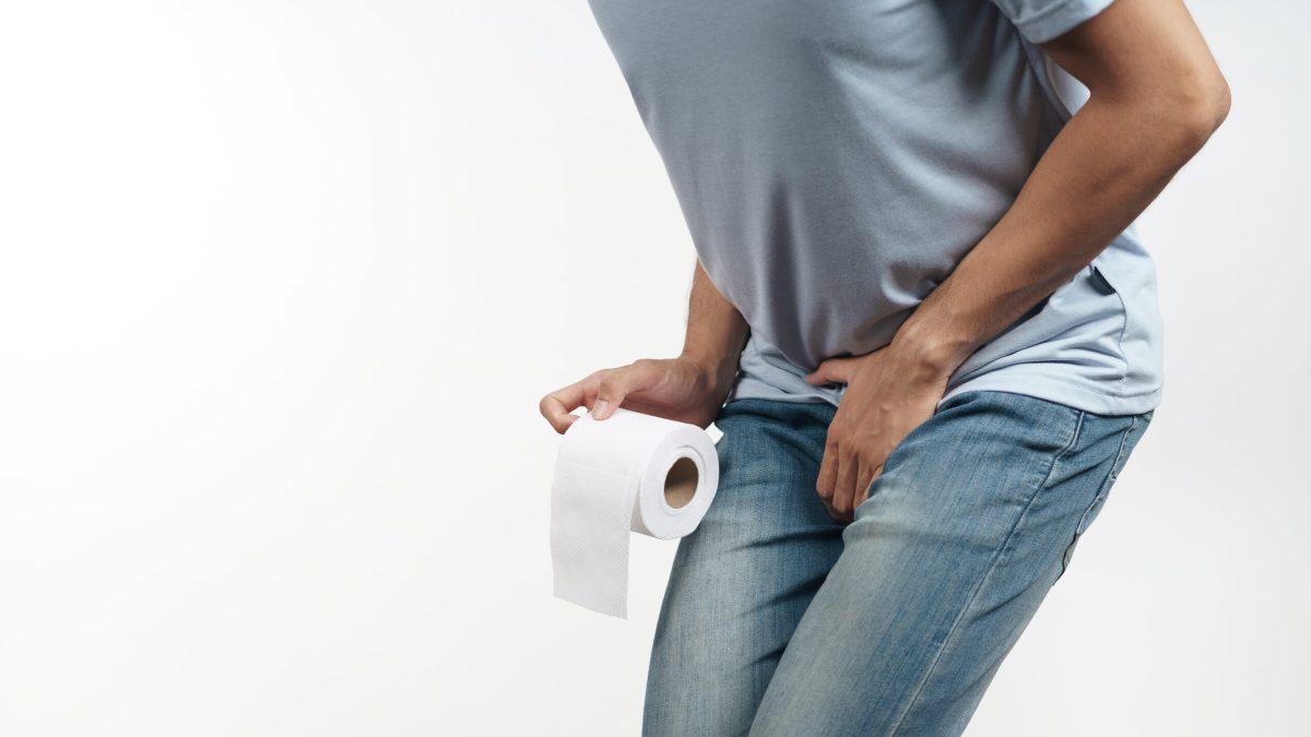 Young man holding his crotch and tissue paper suffering from Diarrhea, incontinence, prostatitis, venereal disease. Healthcare concept.